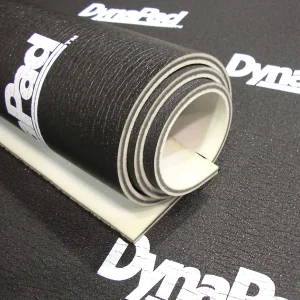 Close-up of a rolled DynaPad underlayment, designed for soundproofing in home theater setups and audio applications.