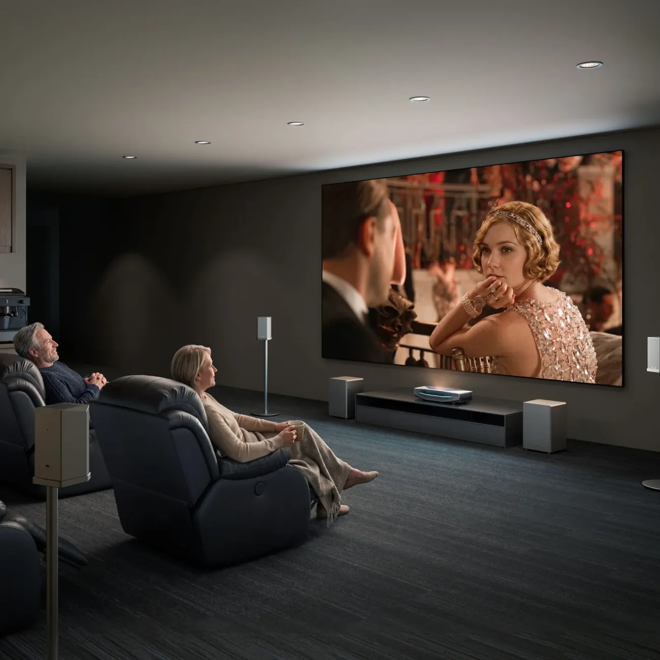 Couple enjoying a movie in a luxurious home theater, featuring a large screen and comfortable seating.