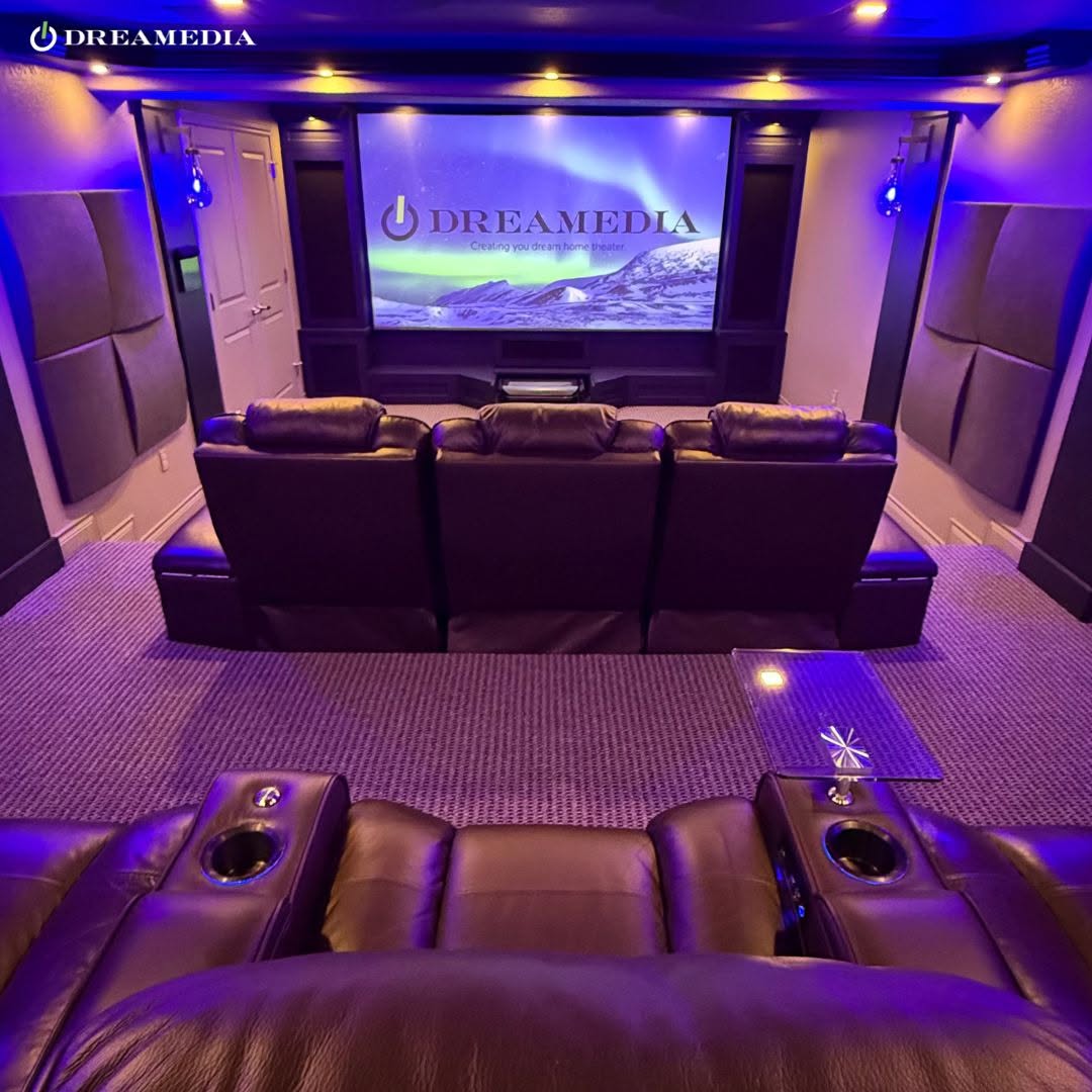 Luxury home theater with purple LED lighting and leather seating.