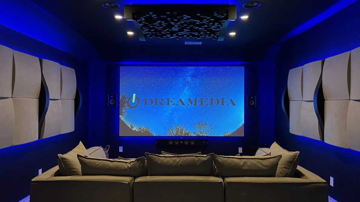 Cozy home theater with blue ambient lighting and a large screen showcasing Dreamedia branding, perfect for movie nights.