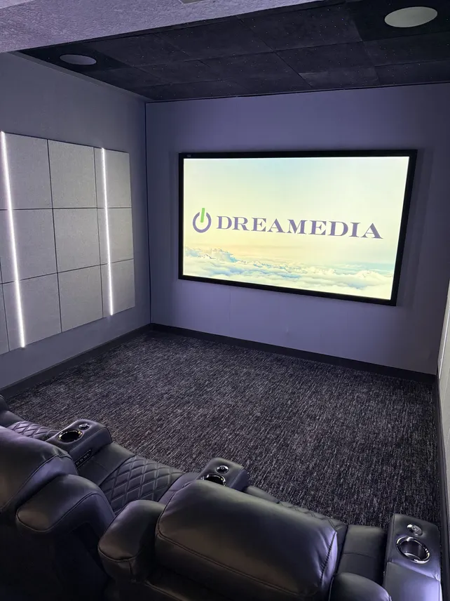Luxury home theater featuring a large screen and comfortable seating, showcasing Dreamedia's modern design elements.